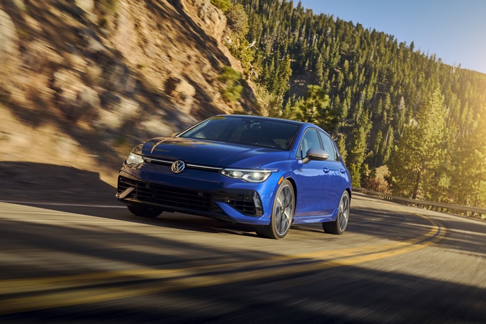 Blue 2022 Volkswagen Golf R driving on a mountain road