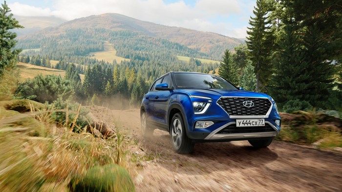 Blue Hyundai Creta driving on a dirt road in mountains