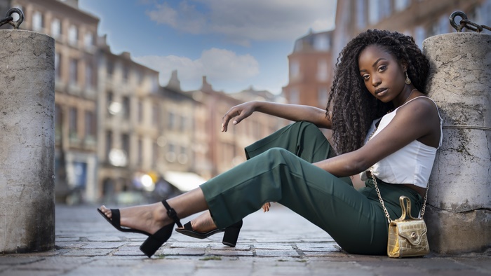 Model with black hair posing in a city street