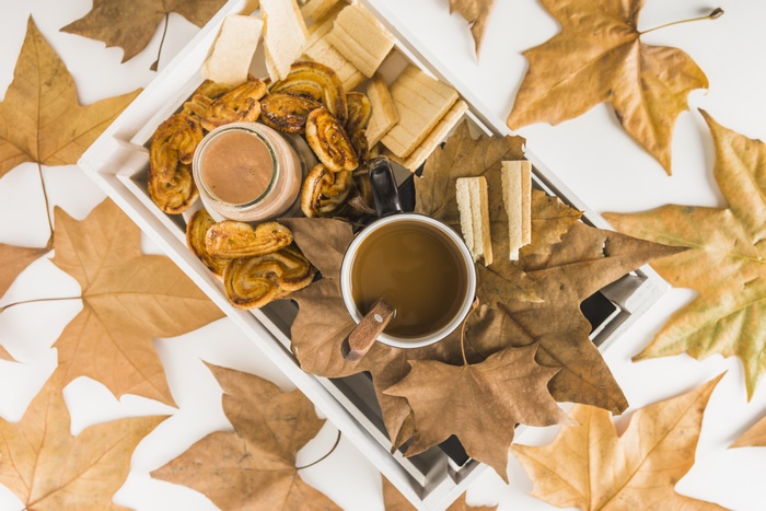 Autumn coffee and cookies with fallen leaves