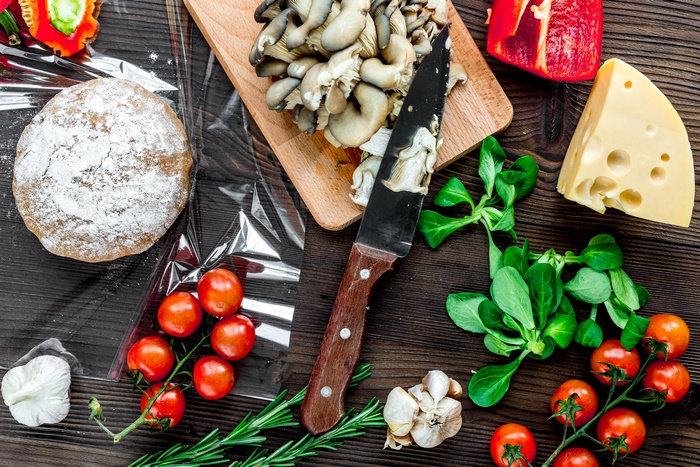Still life of mushrooms, tomatoes, cheese, and bread