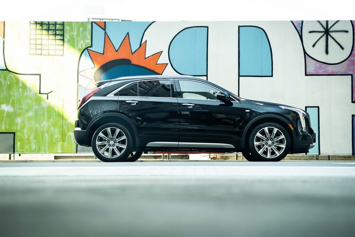 Black Cadillac XT4 Sport parked against a colorful mural