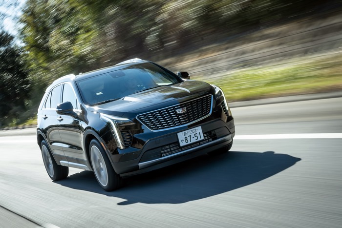 Black Cadillac XT4 350T Sport driving on a road