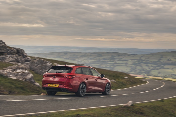 Red Cupra Leon Estate driving on a winding road