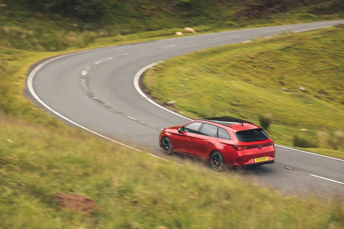 Red 2021 Cupra Leon Estate driving on a winding road