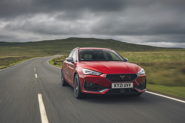 Red 2021 Cupra Leon Estate driving on a country road