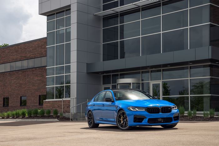 Blue 2021 BMW M5 Competition parked outside modern building