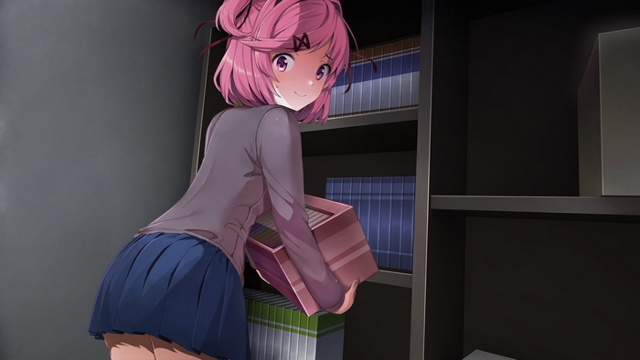 Natsuki holding a box in front of bookshelves