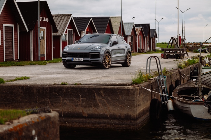 2021 Porsche Cayenne Turbo GT parked by red cabins
