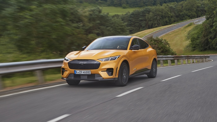 Orange Ford Mustang Mach-E GT driving on a winding road
