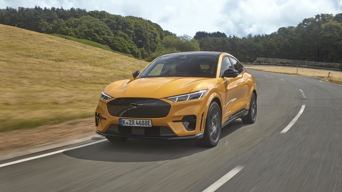 Orange Ford Mustang Mach-E GT driving on a winding road