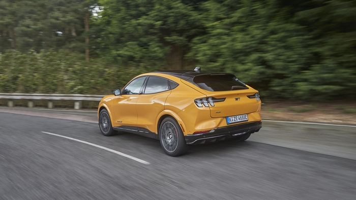Orange Ford Mustang Mach-E GT driving on a road