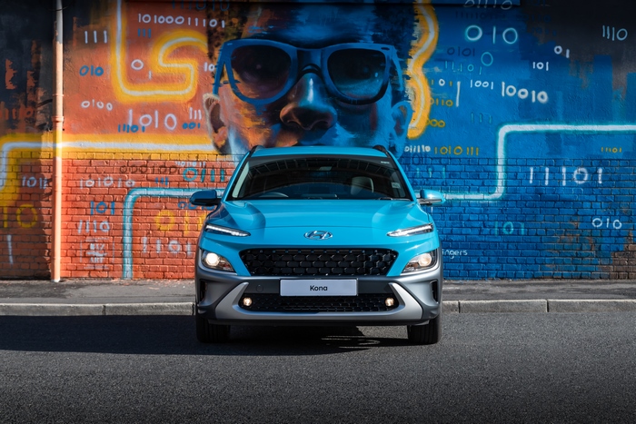 Blue 2021 Hyundai Kona SUV in front of graffiti wall
