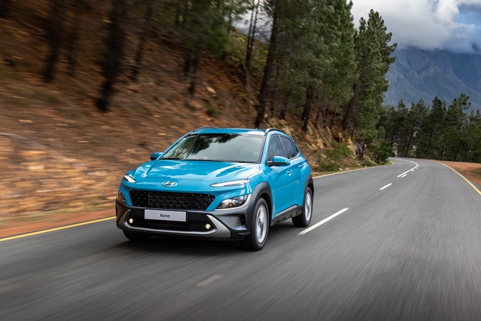 Blue 2021 Hyundai Kona SUV driving on a scenic road