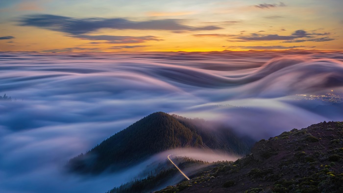 Mountain peak above fog at sunrise 4K