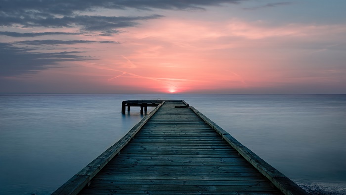 Sunset over the sea with a wooden pier