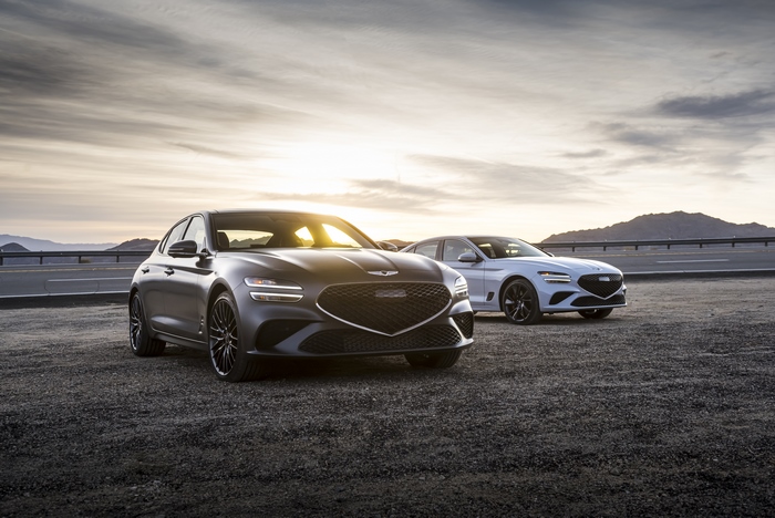 Genesis G70 luxury cars on a road at sunset