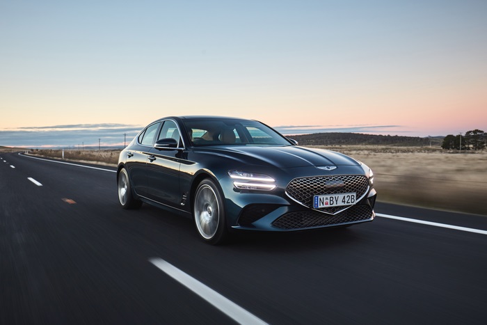 Blue 2021 Genesis G70 2.0T driving on a road