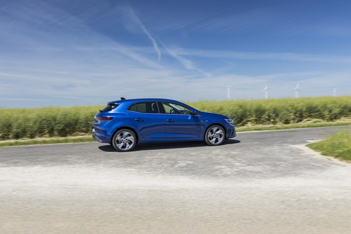 Blue Renault Mégane E-TECH driving on a road