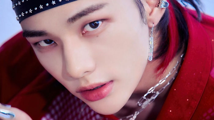 Hyunjin from Stray Kids wearing a red outfit and bandana