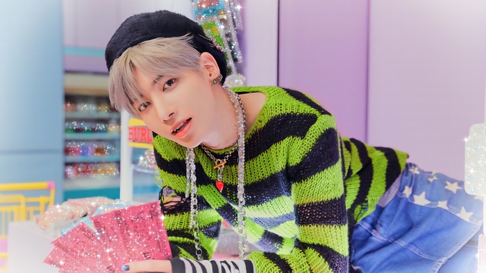 Taehyun from TXT wearing a green and black sweater