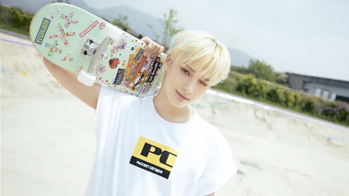 Huening Kai from TXT holding a skateboard