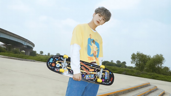 Taehyun from TXT holding a skateboard