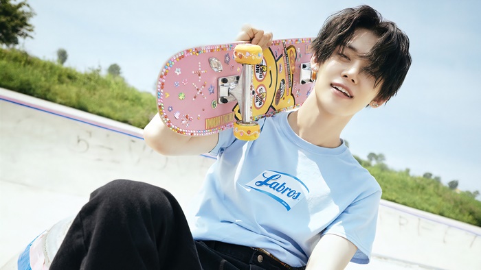 Yeonjun from TXT with a pink skateboard