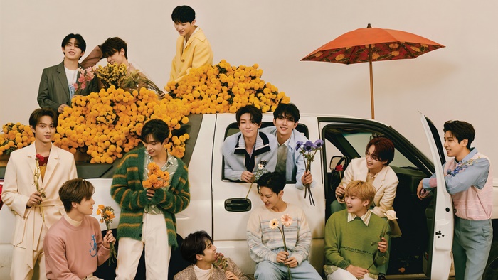 Seventeen members with flowers and a car