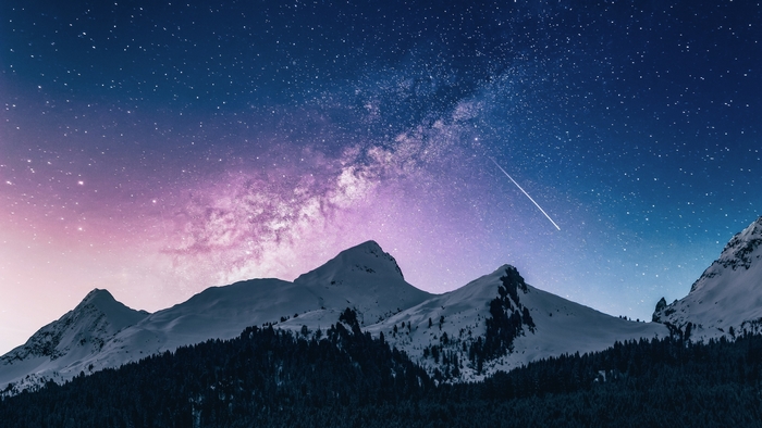 Milky Way over snow-capped mountains with a shooting star
