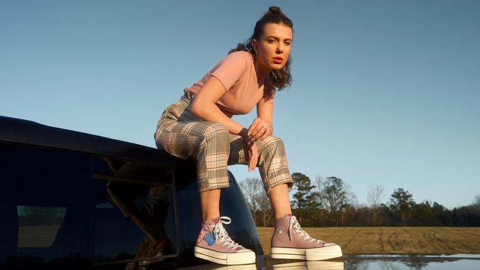 Millie Bobby Brown sitting on a car