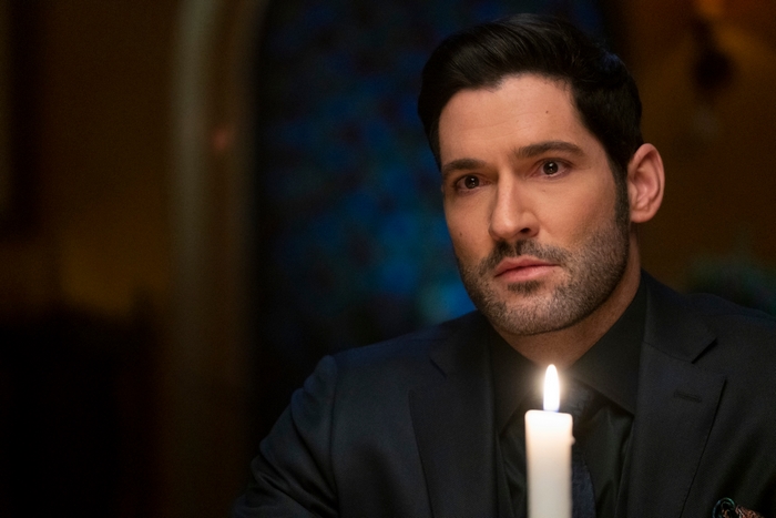 Tom Ellis as Lucifer Morningstar in a suit with a candle