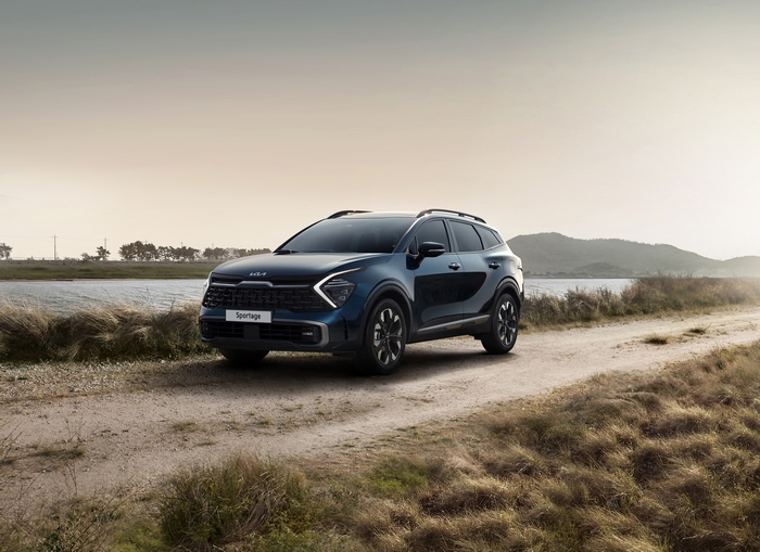 Blue Kia Sportage X-Line SUV on a dirt road