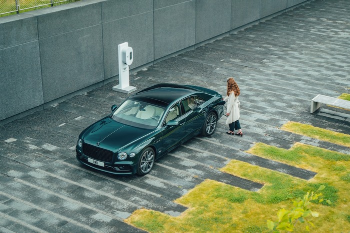 Green Bentley Flying Spur Hybrid charging at a station