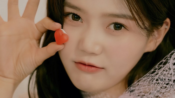 Hyojung from Oh My Girl holding a heart candy