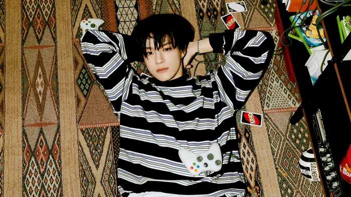Jeno from NCT Dream with UNO cards and game controller
