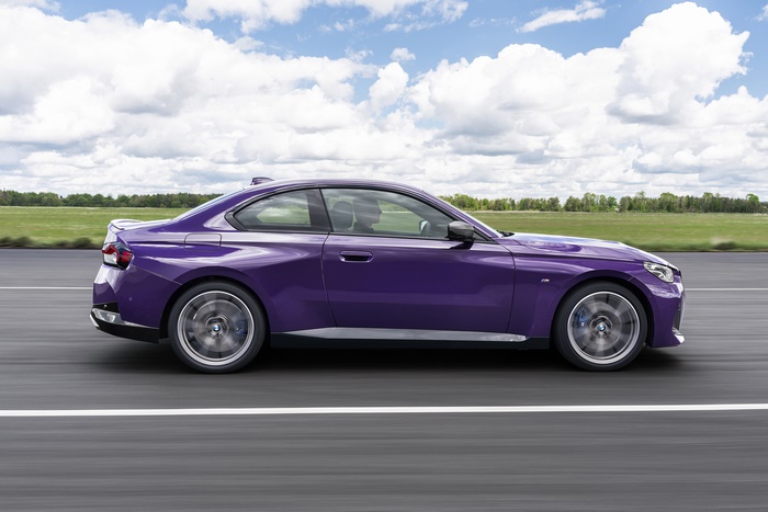 Purple BMW M240i xDrive Coupé driving on a road