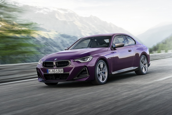 Purple BMW M240i xDrive Coupé driving on a mountain road