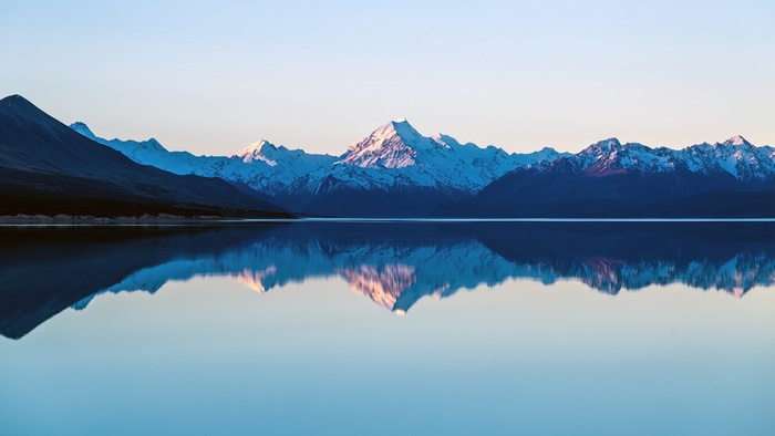 Snow-capped mountains reflected in a calm lake
