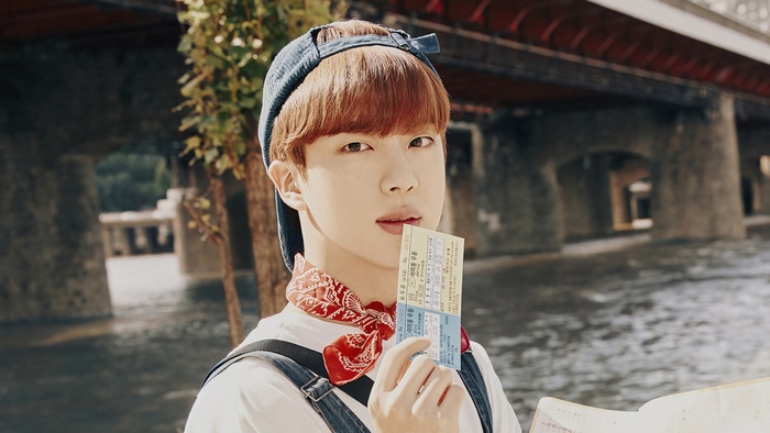 Jin from BTS holding tickets