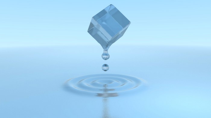 Ice cube melting with water drops and ripples