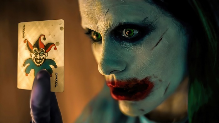Jared Leto as Joker holding a Joker card