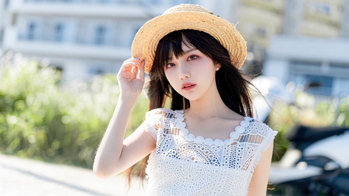 Beautiful Asian girl in straw hat and white dress