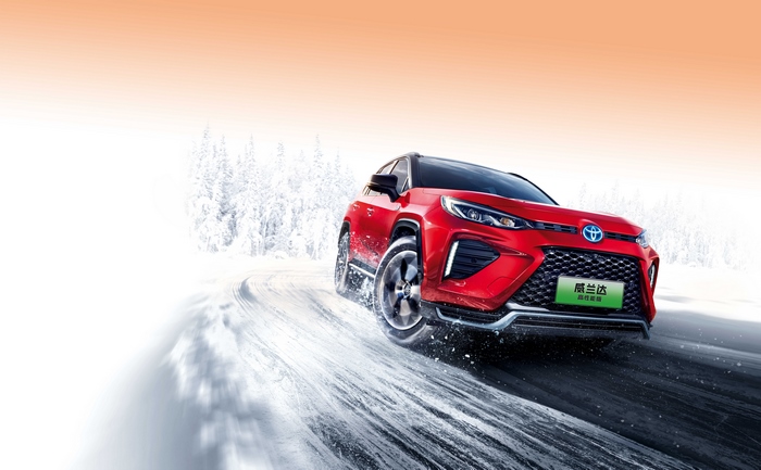 Red Toyota Wildlander PHEV driving on snowy road
