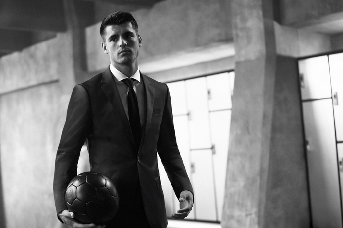 Álvaro Morata in a suit holding a soccer ball