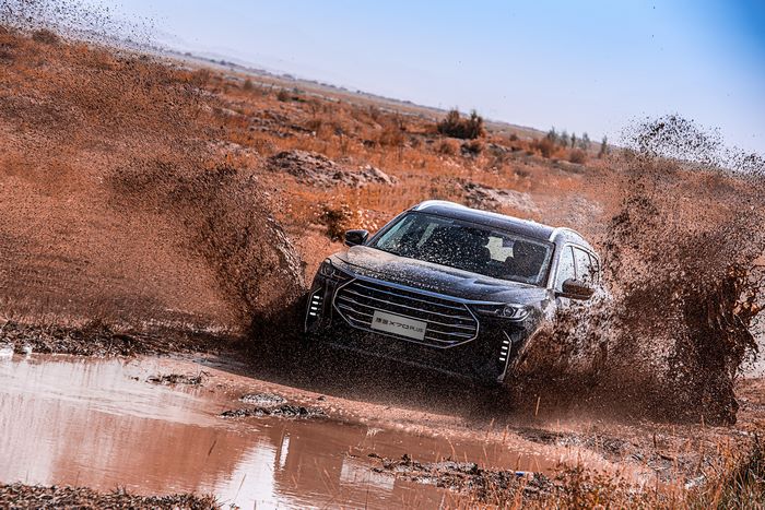 Black Jetour X70 Plus driving through mud