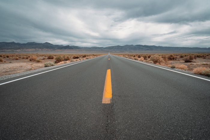 Desert highway under cloudy skies