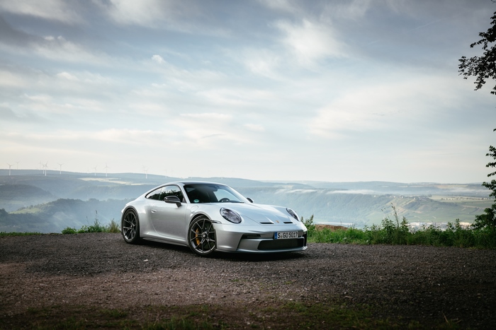 Silver Porsche 911 GT3 Touring on a scenic overlook