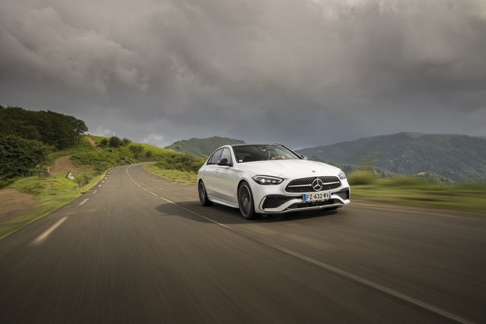 White Mercedes-Benz C 220 d AMG Line on a winding road
