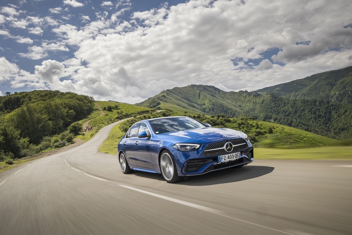 Blue Mercedes-Benz C 200 AMG Line driving on a scenic road